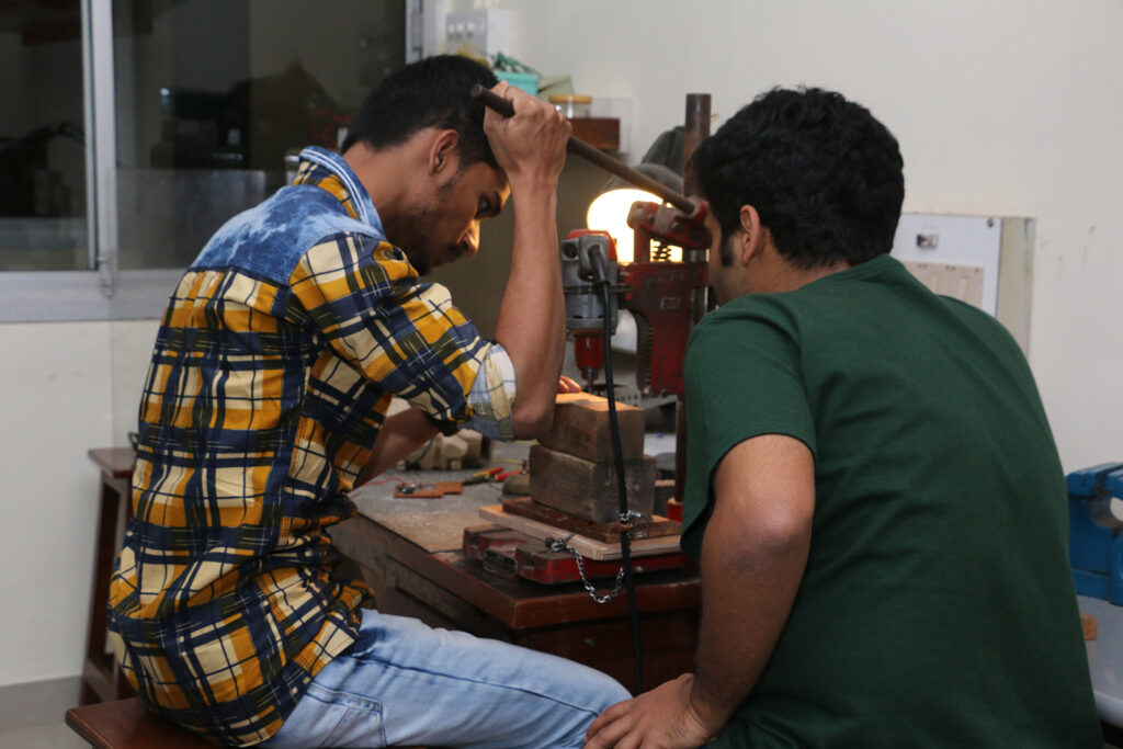 Students using the drill machine to drill PCB